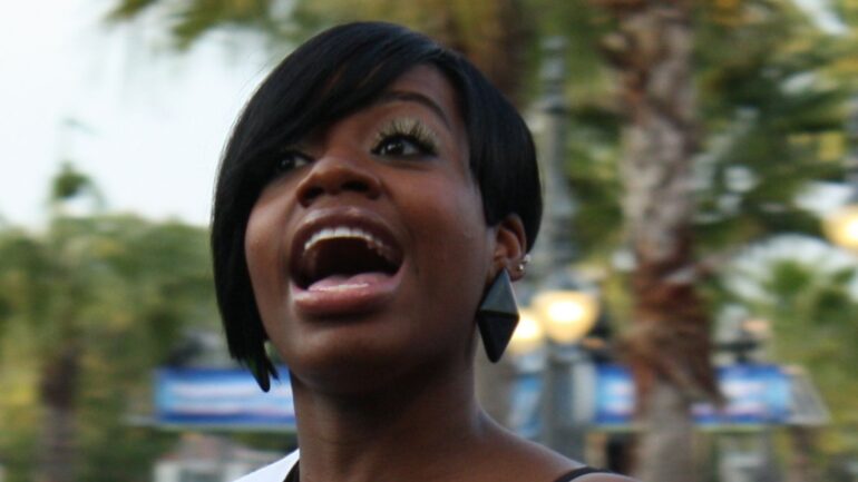 A woman with her mouth open and looking up.