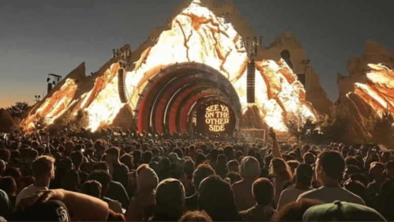 A crowd of people watching an outdoor concert.