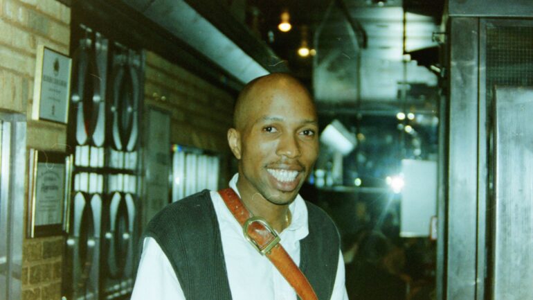 A man with a tie smiling for the camera.