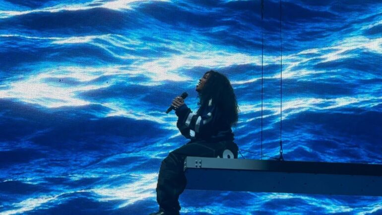 A person sitting on top of a stage with a microphone.