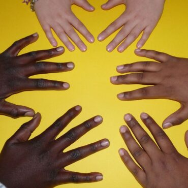 A group of hands are in the shape of a heart.
