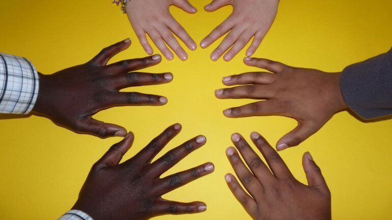 A group of hands are in the shape of a heart.